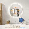 A bathroom scene featuring a round LED mirror with condensation, a sink, and a wooden shelf. Náhled obrázku produktu