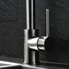A close-up shot of a modern kitchen faucet against a dark, textured tile background. Náhled obrázku produktu