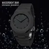 A black watch with Arabic numerals on a black background with water droplets. Produktbild-Vorschau