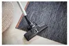 A vacuum cleaner head is shown on a rug next to a woven pouf. Produktbild-Vorschau
