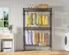 A metal garment rack with two tiers filled with clothing and accessories, set up in a laundry room. Voir les images du produit