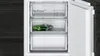 The image shows the interior of an open refrigerator or freezer with three transparent drawers. One drawer contains a green item in a plastic bag. Produktbild-Vorschau