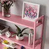 A pink shelf unit with various items on it, including flowers, a framed picture, a plant, a clock, and a water bottle. Voir les images du produit