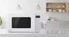 A white Panasonic microwave oven is displayed on a countertop in a modern kitchen setting. Produktbild-Vorschau
