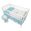 A white wooden crib with blue and white polka dot bedding and a stuffed teddy bear on the duvet. Produktbild-Vorschau