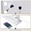 The image shows two close-up views of a vanity mirror with lights. The top section shows a makeup brush being magnified in a circular mirror, with other lights visible on the main mirror. The bottom section shows a smartphone being charged via a USB port o Podgląd zdjęcia produktu