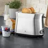 A toaster with bread in it, next to a jar of yogurt and berries, and a loaf of bread. Produktbild-Vorschau