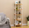 A SONGMICS bookshelf with various decorative items and plants, placed next to a sofa in a room. Produktbild-Vorschau