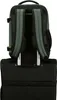 The back of a backpack is shown attached to the handle of a rolling suitcase. Produktbild-Vorschau