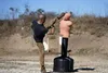 A man is practicing martial arts by kicking a dummy in an outdoor setting. Podgląd zdjęcia produktu