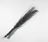 A bundle of twigs tied together with a red band, lying on a white surface. Produktbild-Vorschau