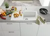 A kitchen counter with a sink, faucet, and various food items. Produktbild-Vorschau
