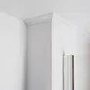 A corner of a room showing white crown molding and a white door frame. Produktbild-Vorschau
