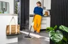A woman is using a steam mop in a modern kitchen. Voir les images du produit