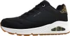 A side view of a black Skechers sneaker with a white sole and brown outsole. The sneaker features a leopard print accent on the heel and a visible air bubble in the sole. Voir les images du produit