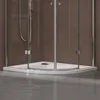 A close-up view of the base of a modern shower enclosure, showing the white shower tray and glass doors. Produktbild-Vorschau