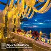 A beautifully decorated outdoor dining area at dusk, overlooking the ocean, with string lights and candles creating a romantic ambiance. Voir les images du produit