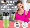 A woman in athletic wear holds a yoga mat and a smoothie cup, with two smoothie blenders in the foreground. Podgląd zdjęcia produktu