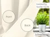 A close-up view of a cream-colored curtain, showing both the front and back sides, with a potted plant in the background. Produktbild-Vorschau