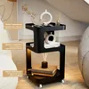 A black three-tiered side table with decorative items on display, placed next to a sofa. Produktbild-Vorschau