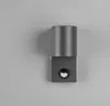 A modern, gray wall lamp with a cylindrical top and a square base containing a small, circular light. Produktbild-Vorschau