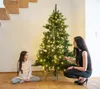 A woman and a child are decorating a Christmas tree. Produktbild-Vorschau