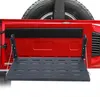 A red vehicle tailgate with a black metal folding shelf attached. Náhled obrázku produktu