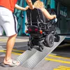 A person is pushing a person in a wheelchair up a ramp into a vehicle. Náhled obrázku produktu
