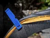 A close-up view of a bicycle tire with a blue tire lever inserted. Produktbild-Vorschau