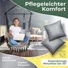 A woman sits in a hanging chair with a laptop, in a living room setting, with pillows and text overlays highlighting product features. Produktbild-Vorschau