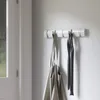 A white wall-mounted coat rack with two items hanging on it. Podgląd zdjęcia produktu