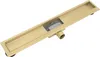 A gold linear shower drain with a grate and outlet pipe, shown from a diagonal angle against a white background. Podgląd zdjęcia produktu