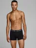 A shirtless man wearing black boxer shorts with a logo waistband stands against a plain background. Produktbild-Vorschau