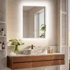 A modern bathroom vanity with a lit mirror, sink, and wooden drawers. Podgląd zdjęcia produktu