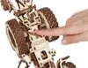 A close-up view of a wooden model tractor's mechanical parts, with a finger interacting with a component. Náhľad obrázku produktu