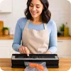 A woman is using a vacuum sealer machine to package a piece of salmon. Podgląd zdjęcia produktu