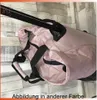 Close-up view of a pink duffel bag with black straps and handles, with a wooden plank background. Voir les images du produit
