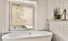 A clean, modern bathroom with a bathtub and a window covered by blinds. Produktbild-Vorschau