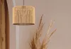 A close-up of a woven pendant lamp with dried pampas grass in the background. Náhľad obrázku produktu