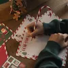 A person is writing a letter to Santa Claus with a candy cane-shaped pencil. Anteprima dell’immagine prodotto