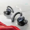 Two black wireless earbuds are shown on a wet surface, with a red fabric in the foreground. Produktbild-Vorschau