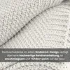 A close-up view of a textured, knitted blanket. Náhľad obrázku produktu