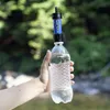A hand holds a water bottle with a Sawyer water filter attached, outdoors with trees in the background. Produktbild-Vorschau