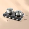 A black induction cooktop with two pots on it, with dimensions indicated. Produktbild-Vorschau