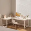 A white L-shaped desk with a computer, books, and a chair in a room with blinds. Produktbild-Vorschau