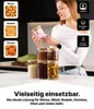 Frau, die ein klares Glas-Aufbewahrungsglas mit Bambusdeckel, gefüllt mit rosa Marshmallows, hält, mit anderen mit verschiedenen Lebensmitteln gefüllten Gläsern auf einer Küchenarbeitsplatte Produktbild-Vorschau