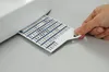 A hand is holding a card with stitch patterns, inserting it into a sewing machine. Produktbild-Vorschau