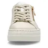 A close-up front view of a beige platform sneaker with gold accents. Náhled obrázku produktu