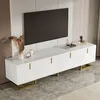 A white TV stand with gold accents is shown in a modern living room setting. Produktbild-Vorschau