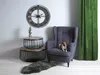 A living room scene with a dog sitting on a chair next to a set of tables and a large clock on the wall. Produktbild-Vorschau